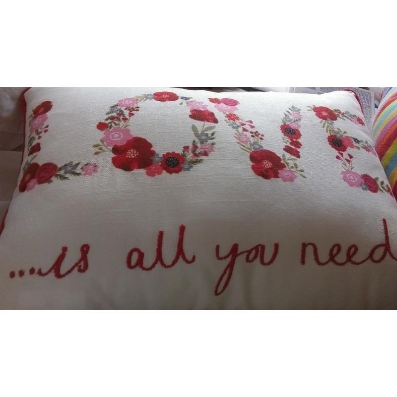unwated gift small red cream cushion free with the words love is all you need