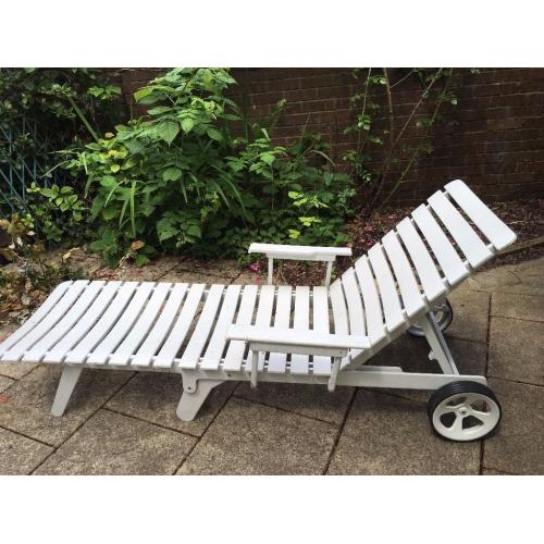 A pair of white plastic sun loungers