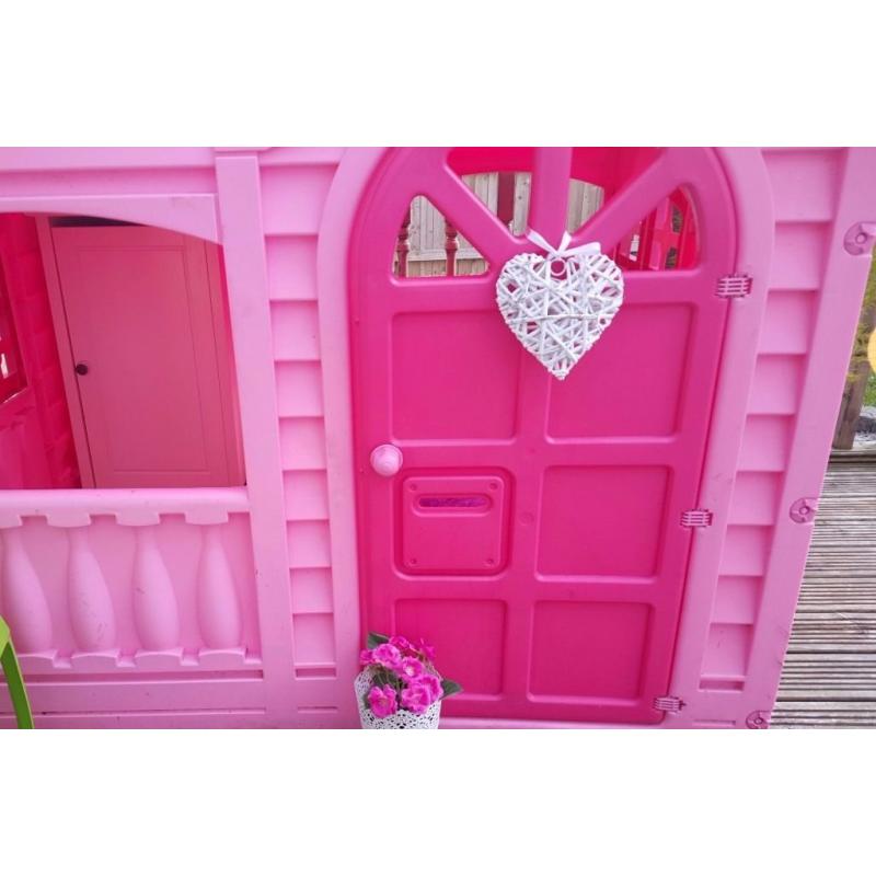 pink playhouse cottage with table and chairs
