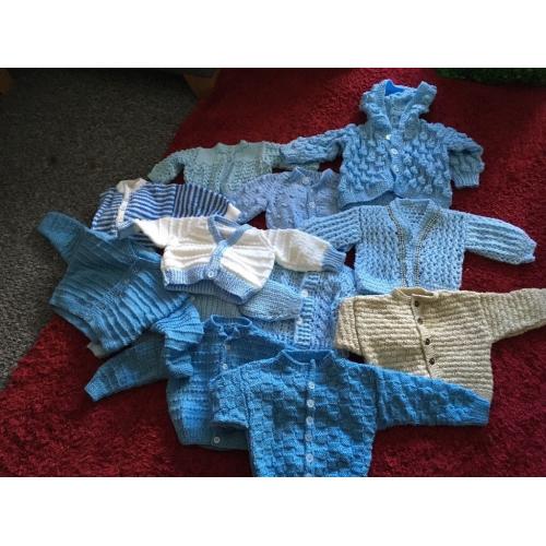 Baby boys knitted cardigans, hats and mittens.