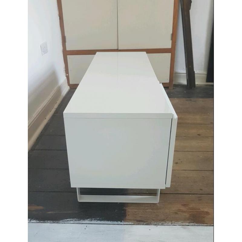 Gloss white TV stand unit with drawers and door at one end